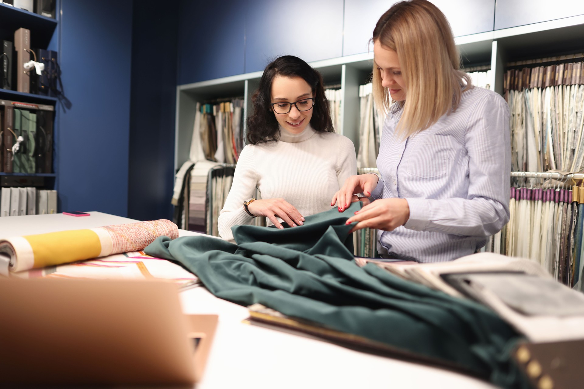 Consultant with customer is choosing fabrics in store.